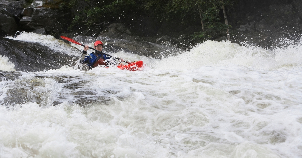 Whitewater kayaker in rapids.