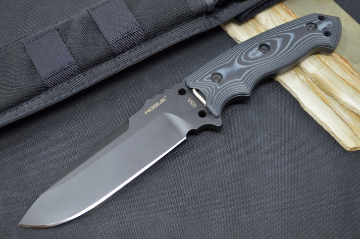 An image of the Hogue EX-F01, a fixed blade knife, on a simple black and wood background.