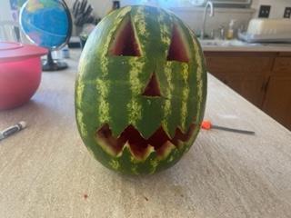 A watermelon carved into a face

Description automatically generated