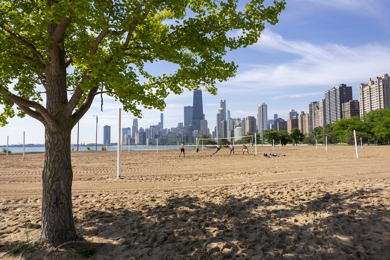 A group of men playing beach volleyball on the shore of Lake Michigan in Chicago.