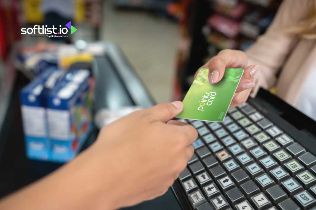 Hand exchanging a green point card at the grocery store counter