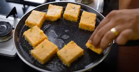 Shallow frying the pieces in a pan until golden brown and crispy.