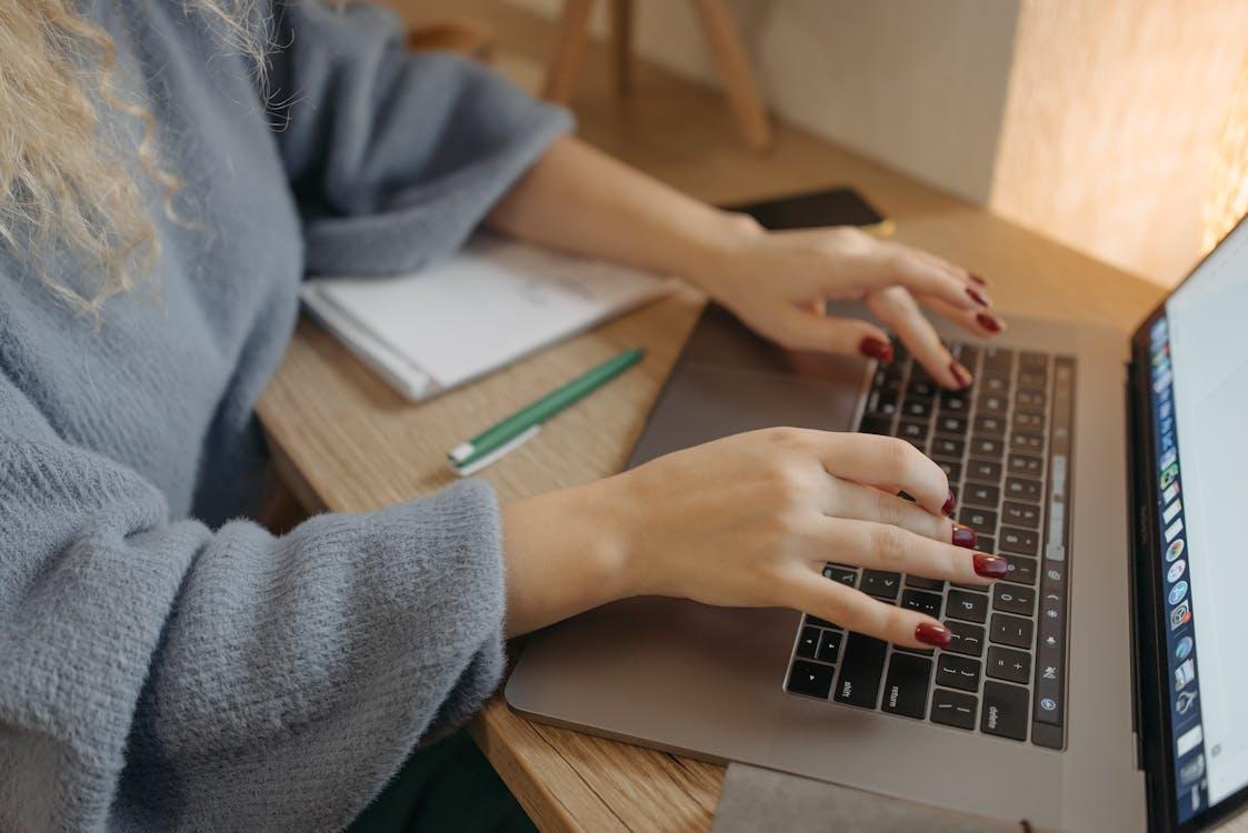 Free Person Typing on a Macbook  Stock Photo