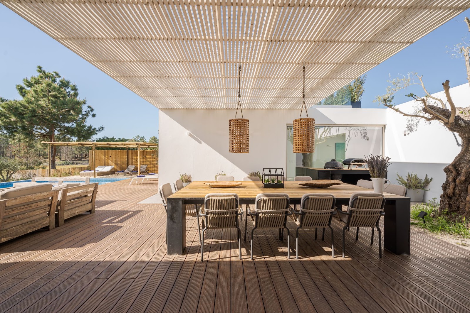This modern villa has a pool, spacious deck, and interior and exterior views.