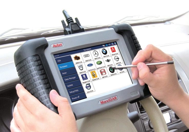 A technician holding a telematics based auto-diagnostic tool 