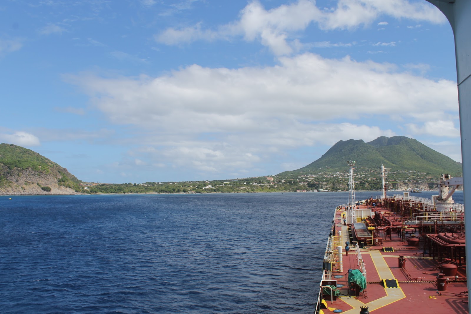 Mountain view from a ferry on the blue waters of St. Eustatius beach.