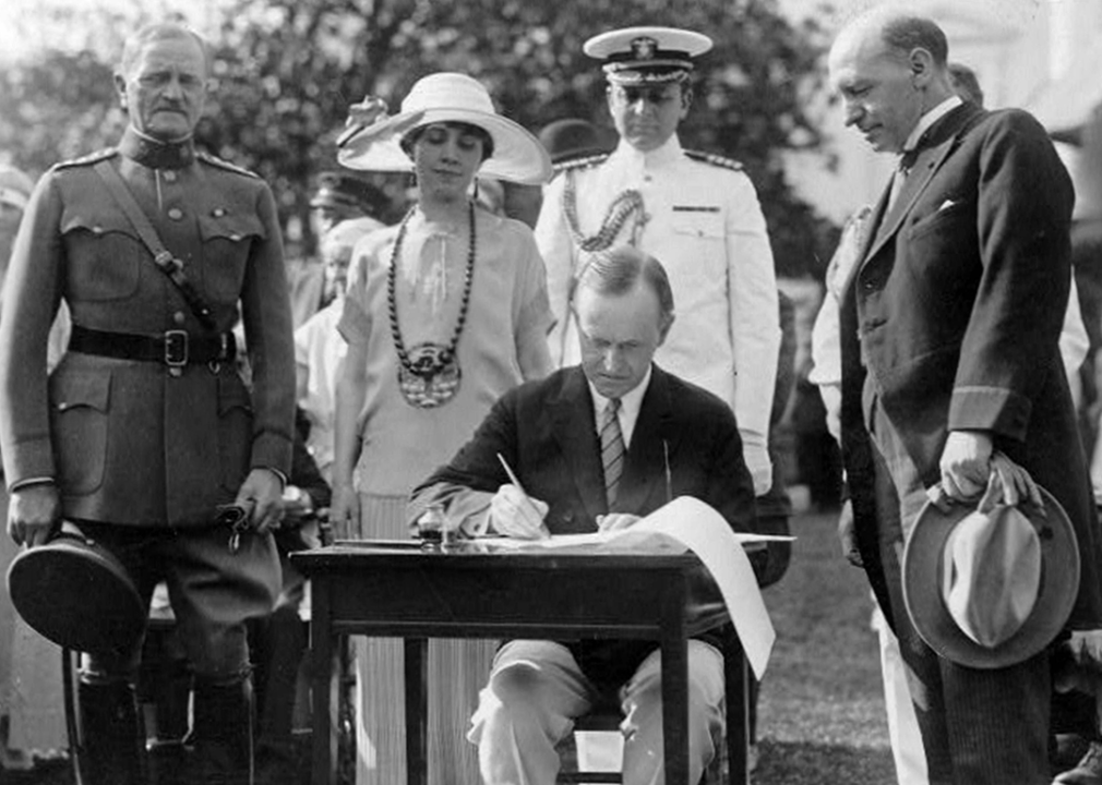 Calvin Coolidge firma el proyecto de ley sobre veteranos en el césped de la Casa Blanca.