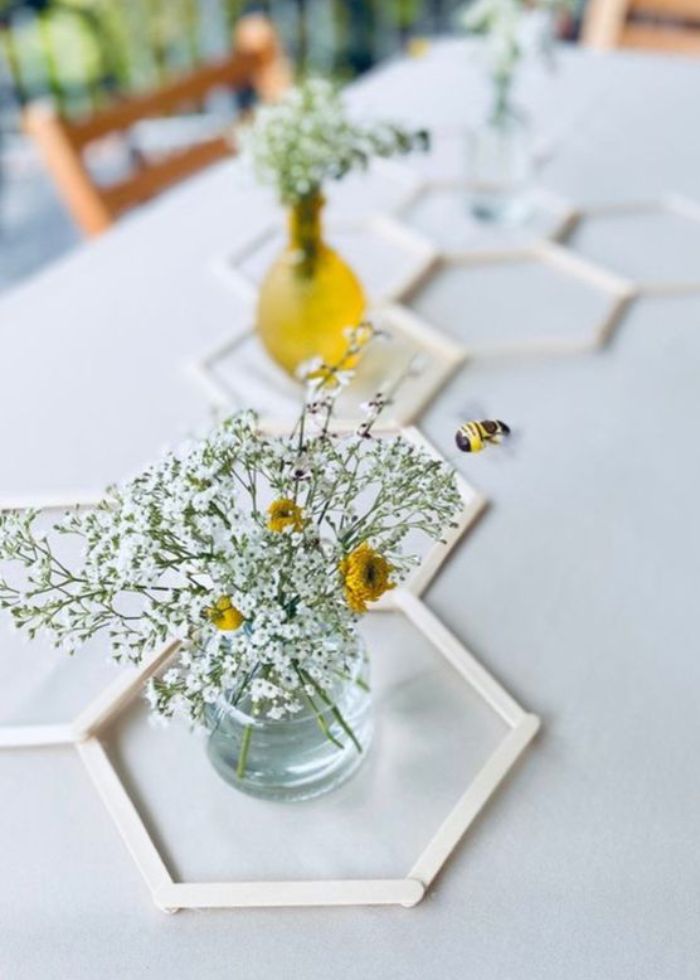 honeycomb table display with flowers and bees