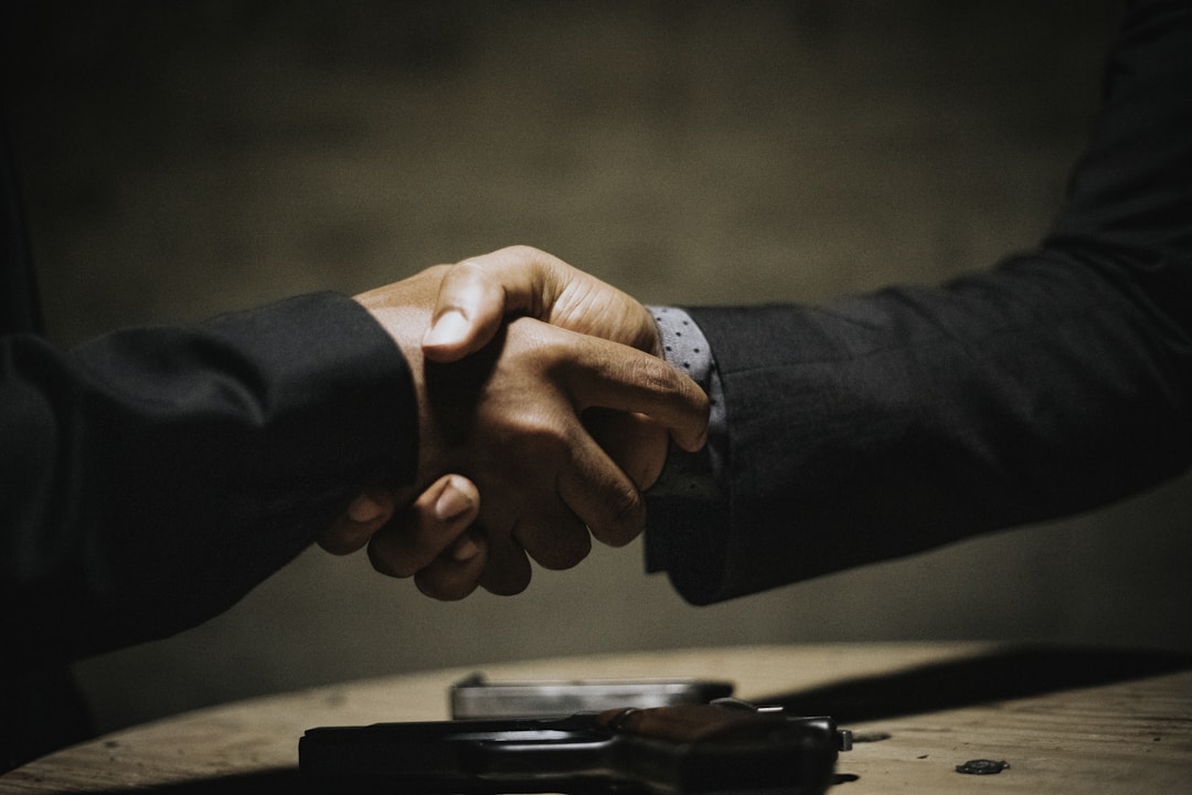 Two co-workers have an agreement in the form of a firm handshake.