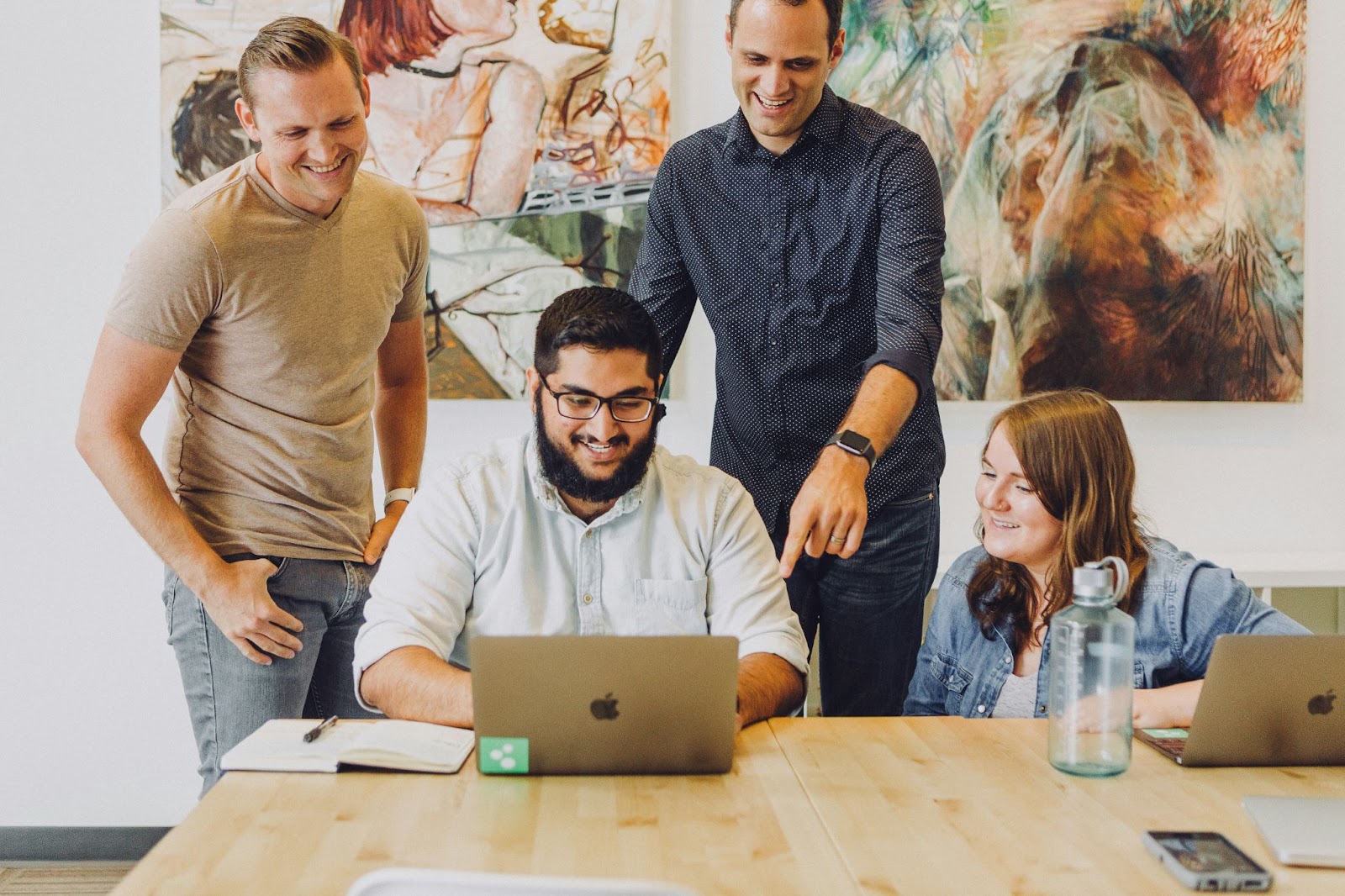 Work colleagues gathered around a laptop