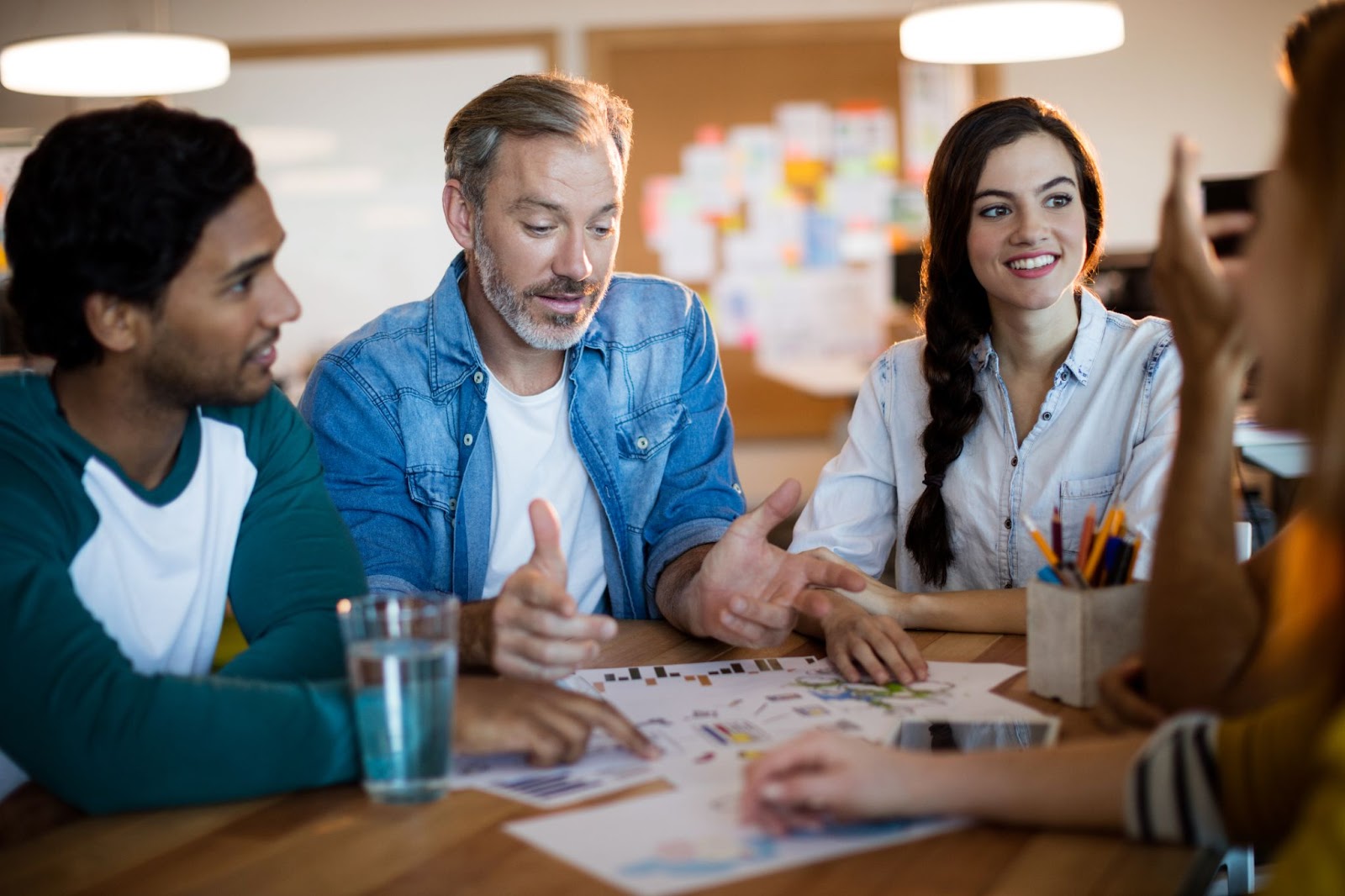 A creative team discusses plans and designs in a meeting. 