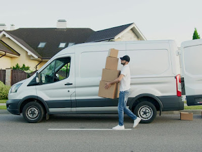 Man carrying boxes beside a van