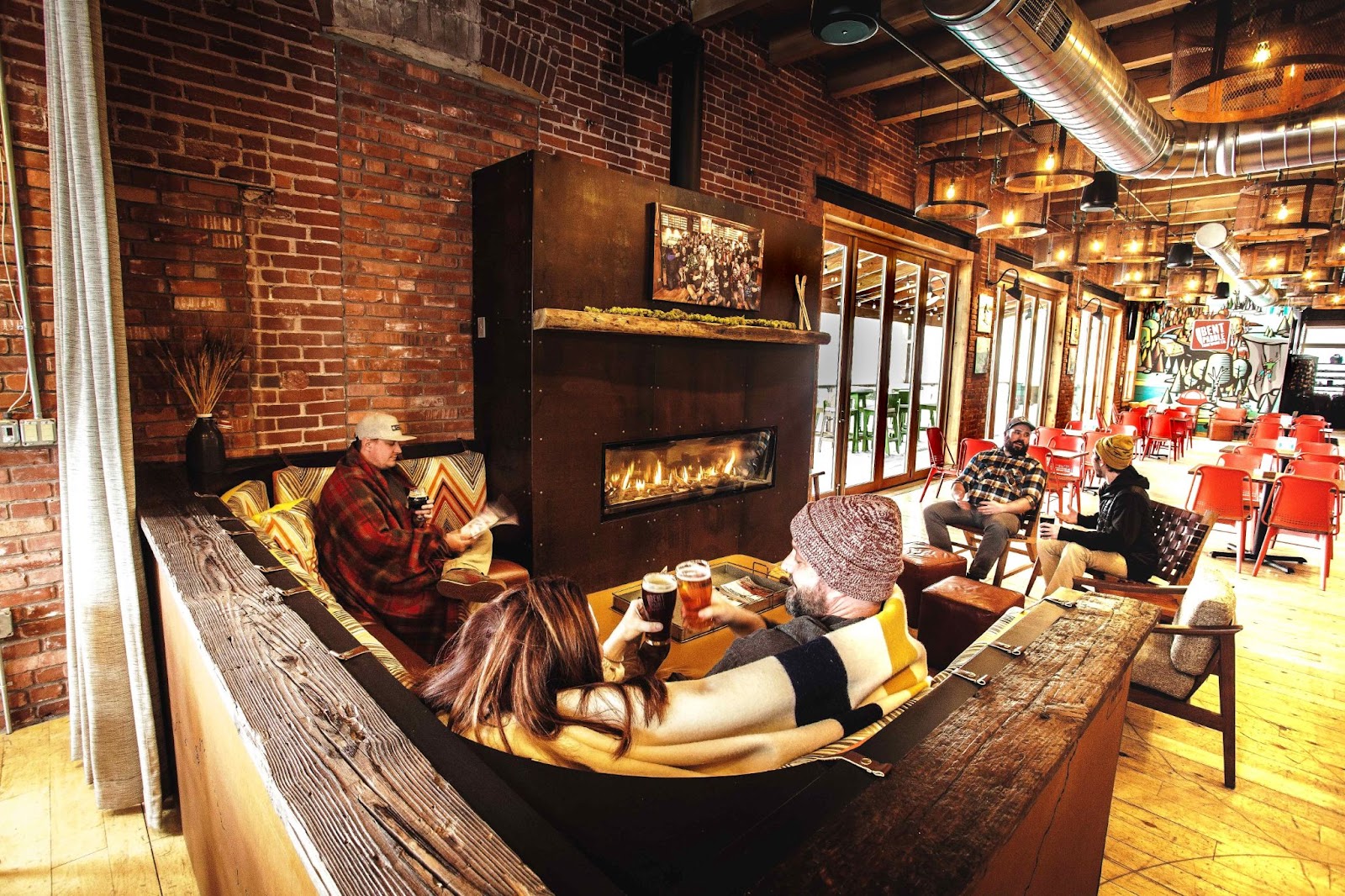 Bent Paddle fireplace area with people cheersing and reading books