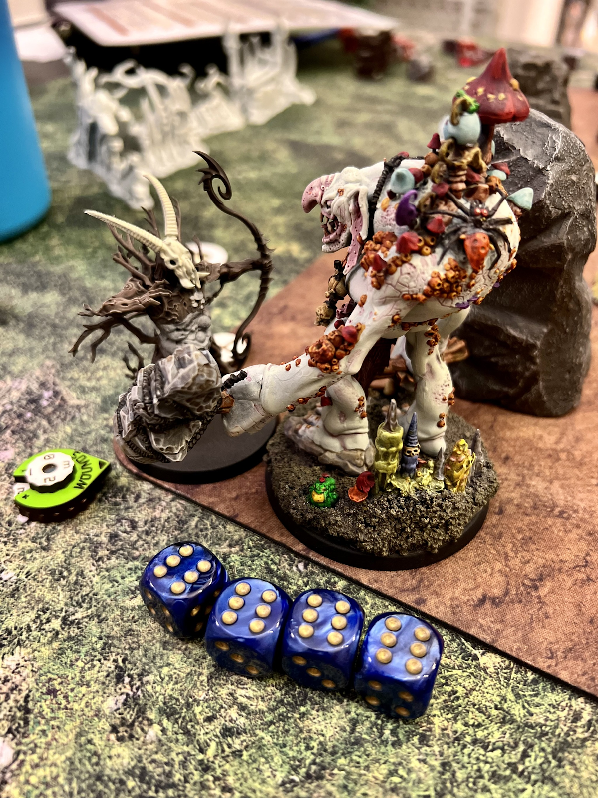 A toy figurine with horns and a pair of blue dice Description automatically generated