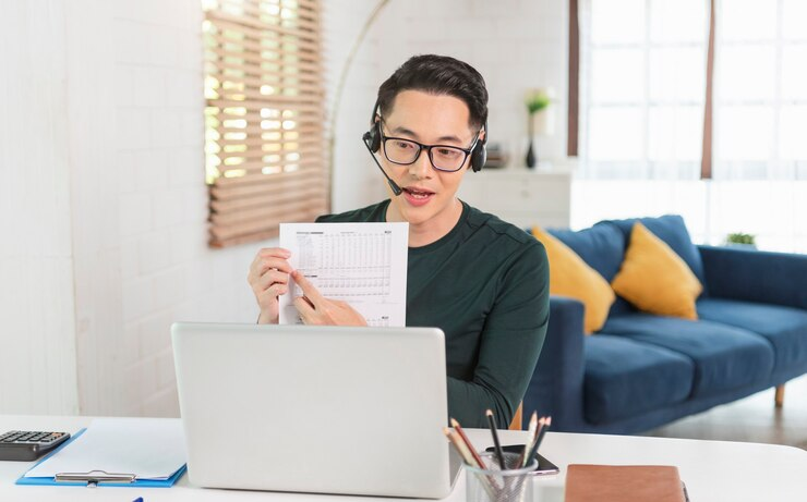 Man in headset presenting a document during an online meeting.