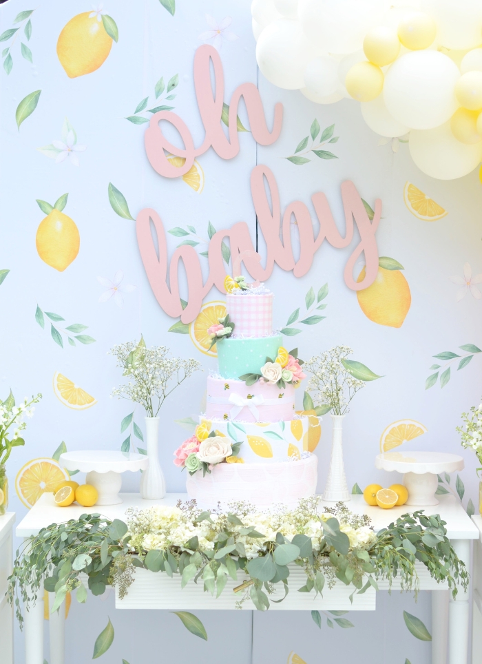 pink oh baby sign hanging over lemon themed baby shower food table