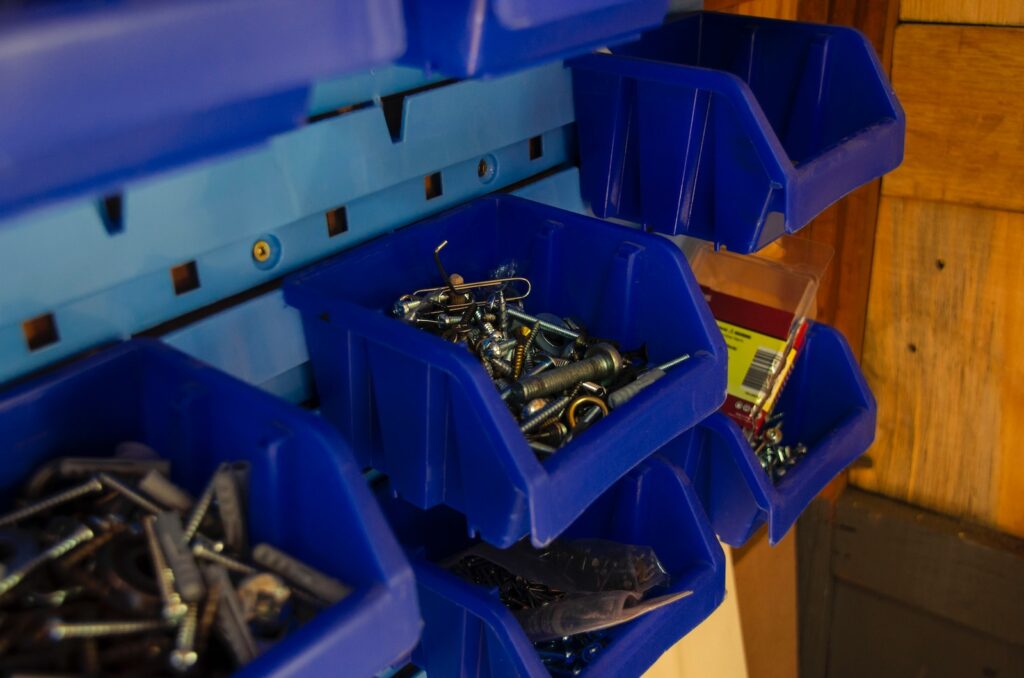 a blue bin filled with lots of screws and nuts