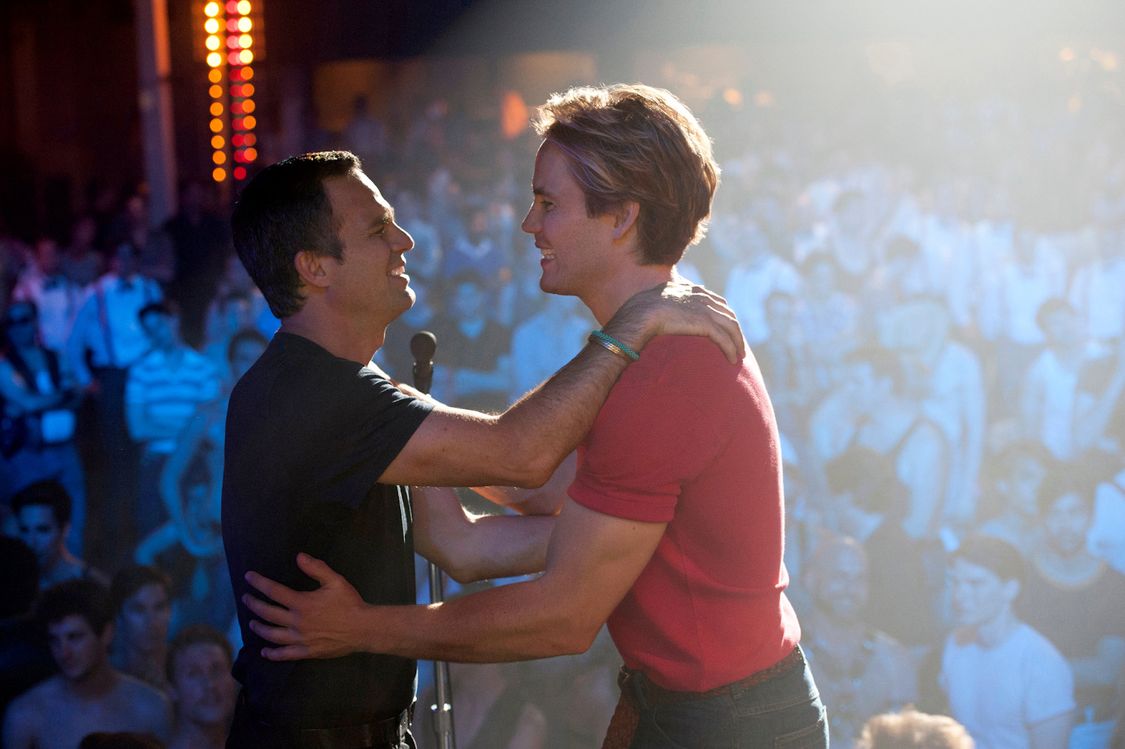 Dos hombres abrazándose en un escenario ante una multitud en The Normal Heart (2014), una de las mejores películas LGBT+ de Max.