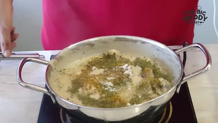 Whisked yogurt and spices being added to the pan for the Chicken Kali Mirch gravy.