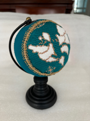 A small globe with a white and blue design

Description automatically generated with medium confidence