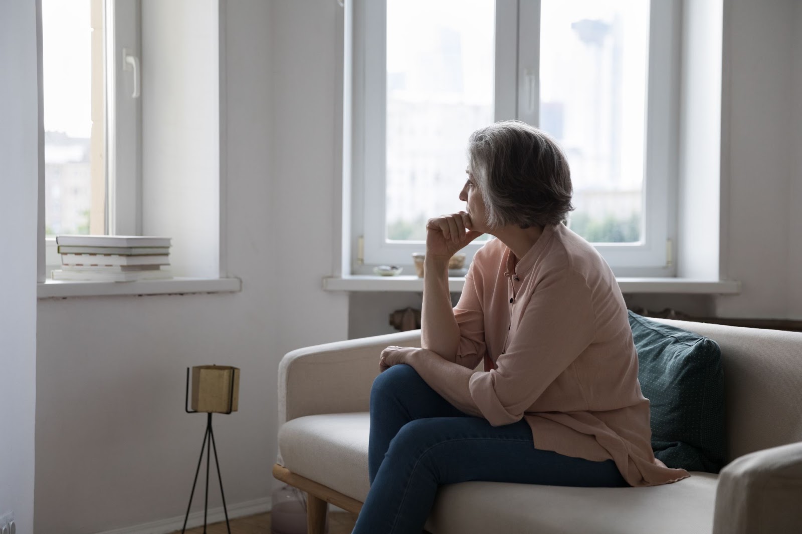 Older aged woman sitting alone at a senior living community, looking upset