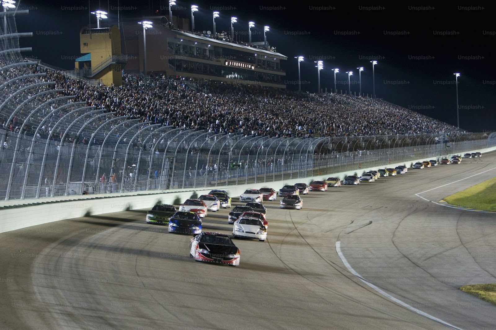 a group of cars driving down a race track