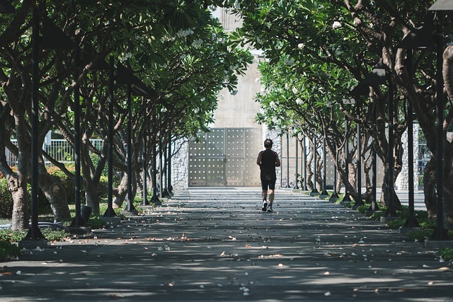 A man is walking in green trees to manage stress