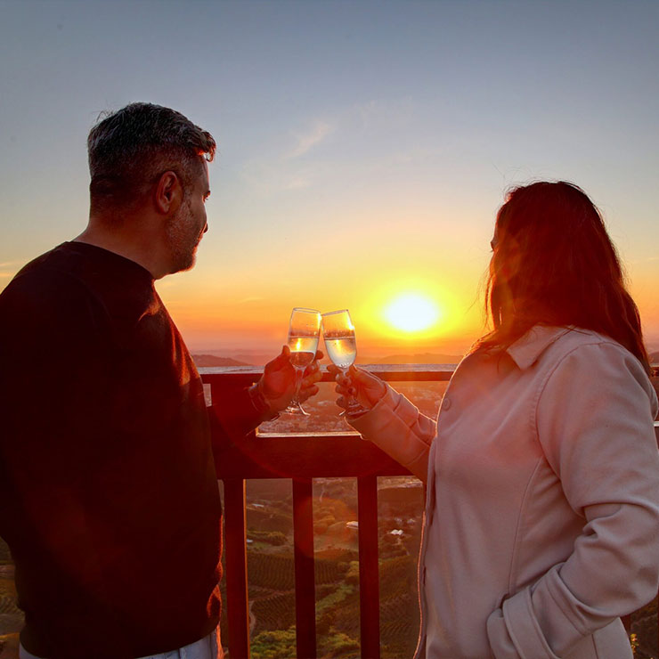 Imagem de casal vendo pôr do sol na região de Serra Negra à noite