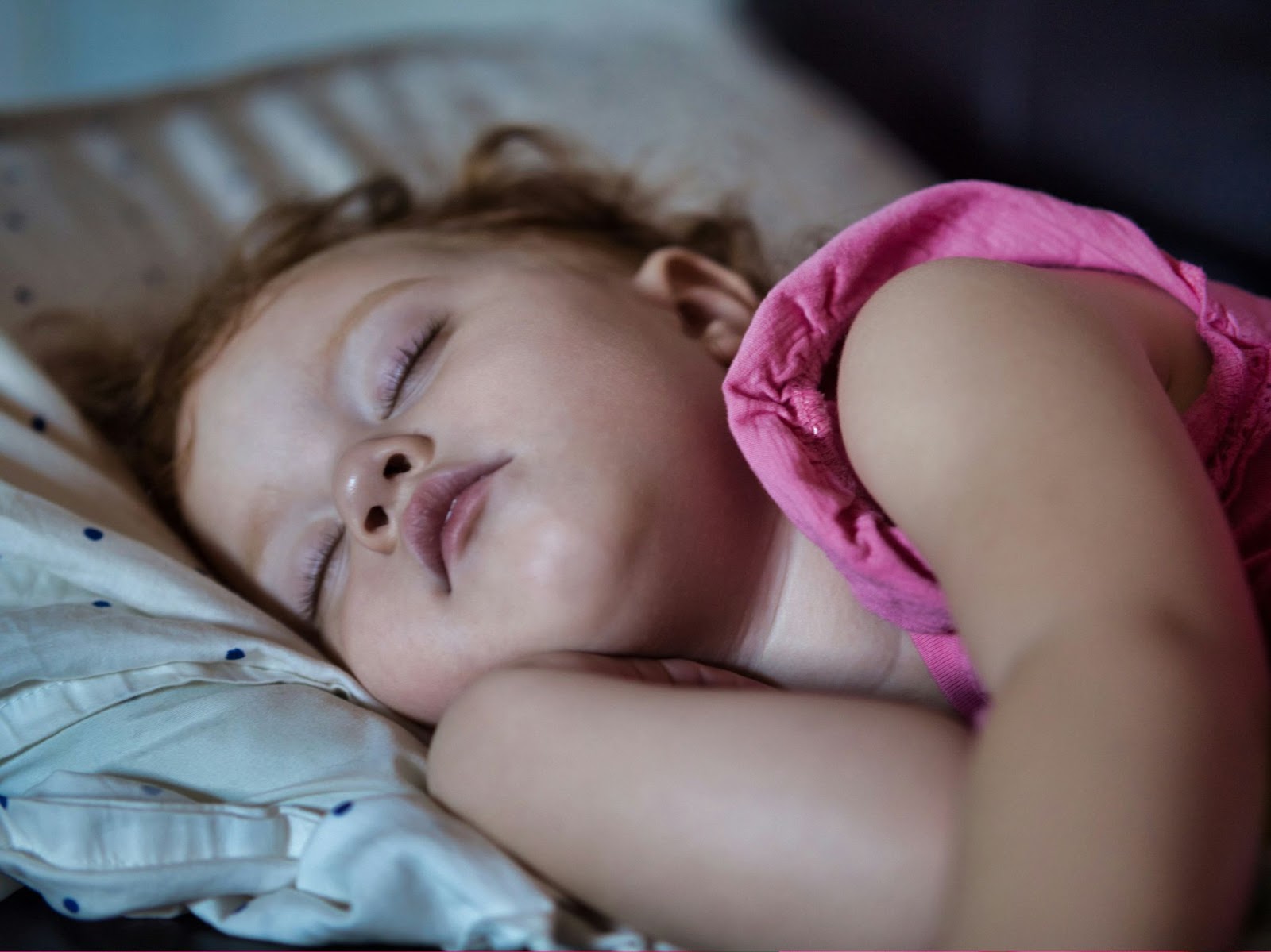 Close-up of a sleeping little girl in pink