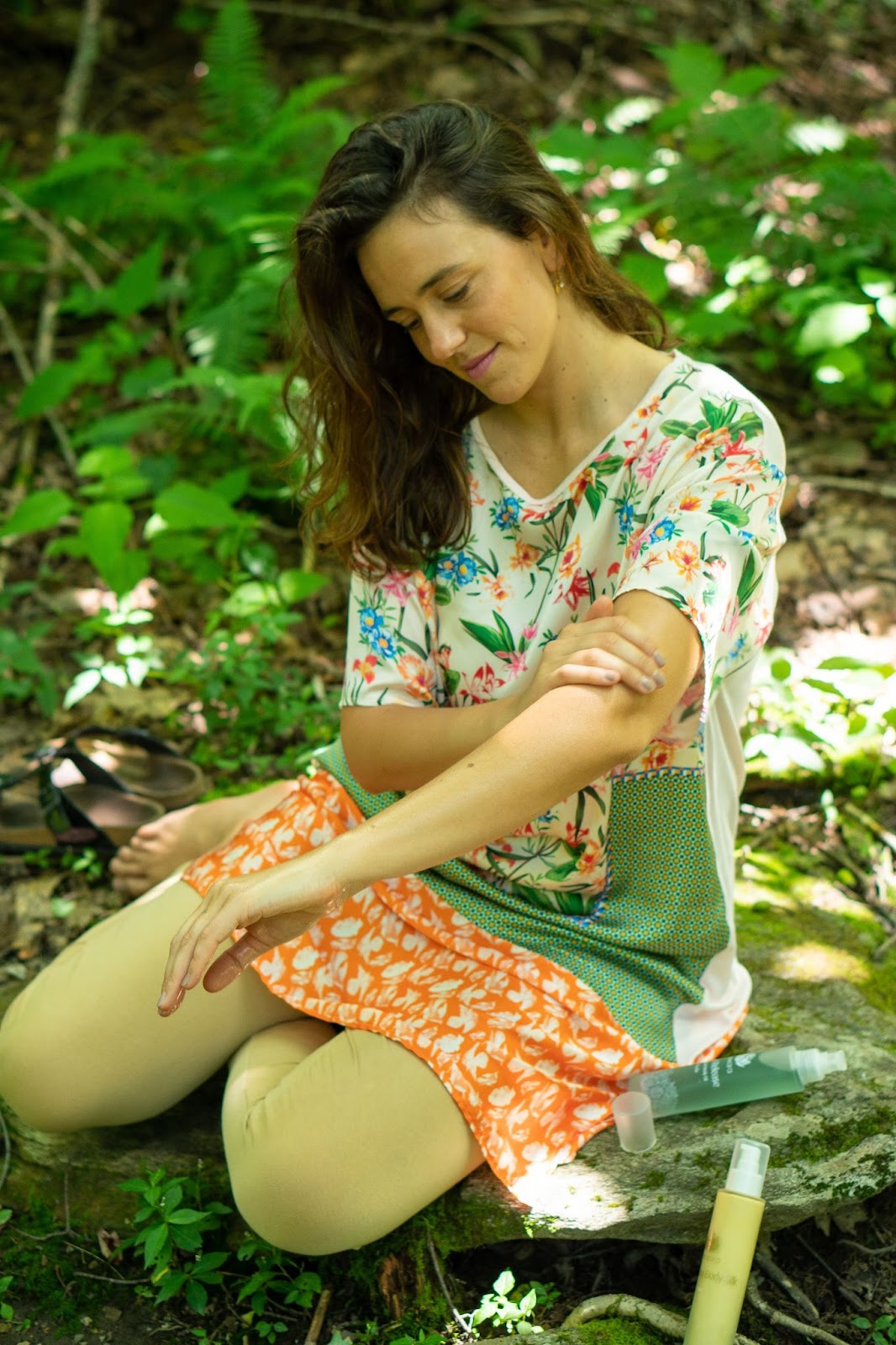 Female sitting in the forest applying Shanakra Naturals Moisturizer