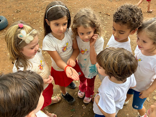 Imagem mostra várias crianças reunidas em um círculo.