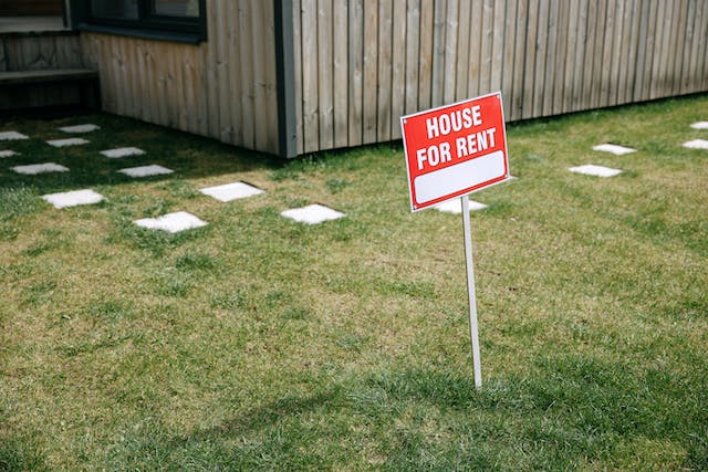 A “for rent” sign in a front lawn.