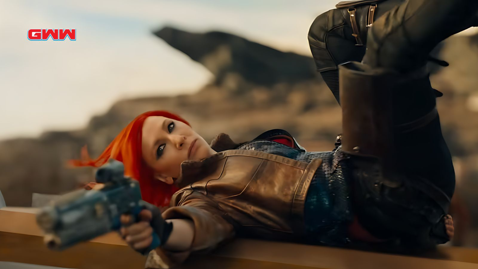 Lilith with red hair, lying down, aiming a futuristic gun.