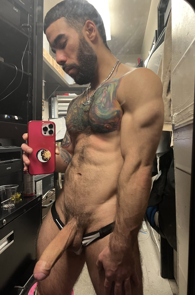 Papi Suave posing backstage in a tiny little thong with his massive erect dick hanging out of his underwear while taking an iphone mirror selfie