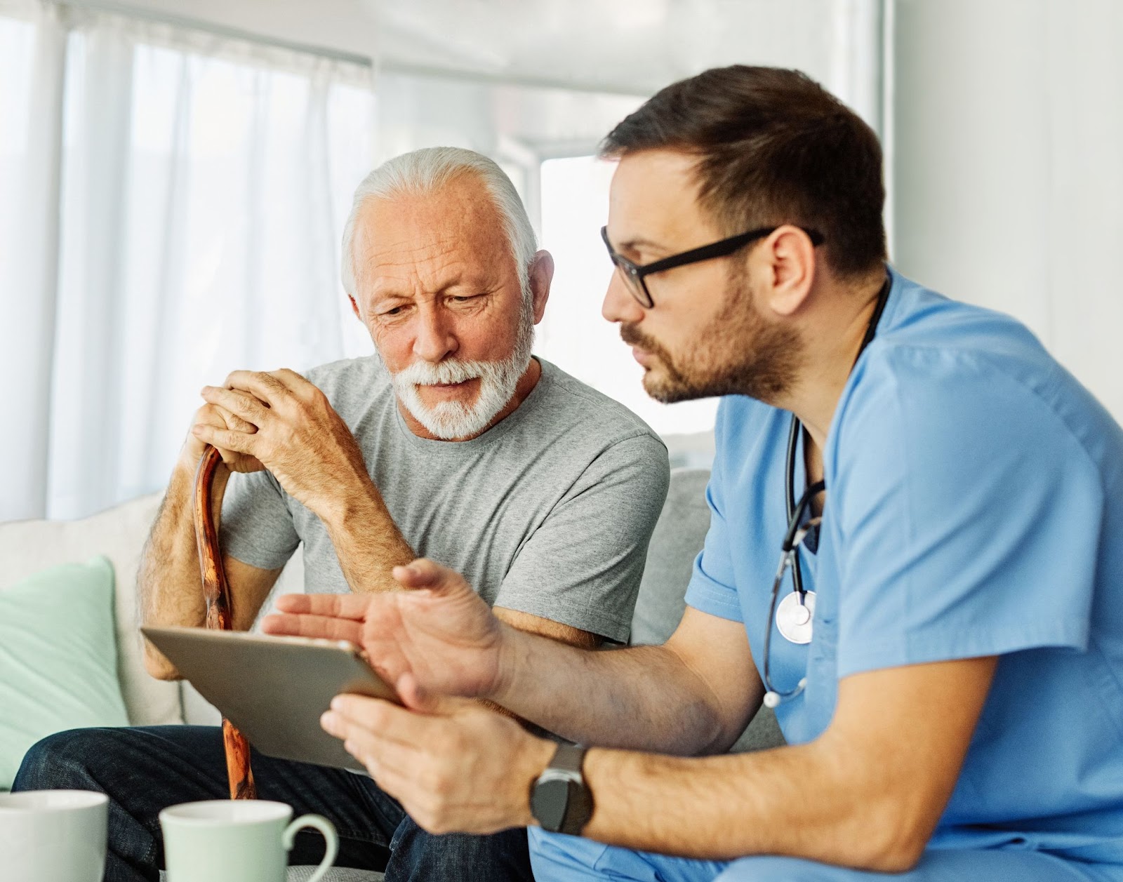 A male doctor showing a senior man a tablet with a plan for a healthy and senior-friendly keto diet.