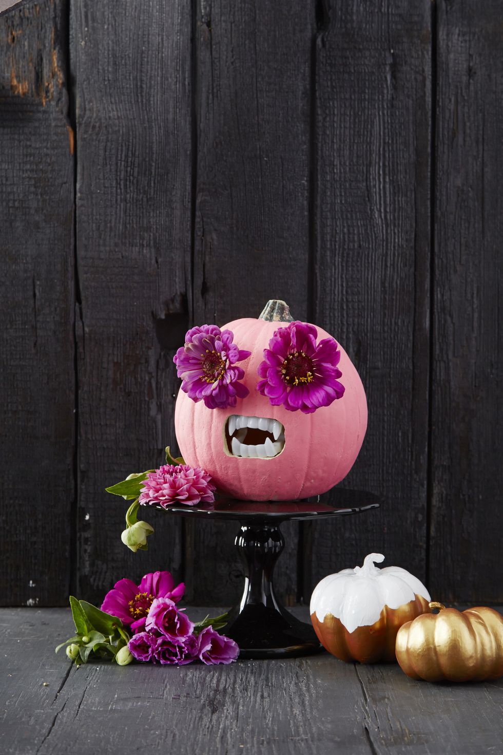 pumpkin carving ideas, pink pumpkin with flowers for the eyes and sharp teeth