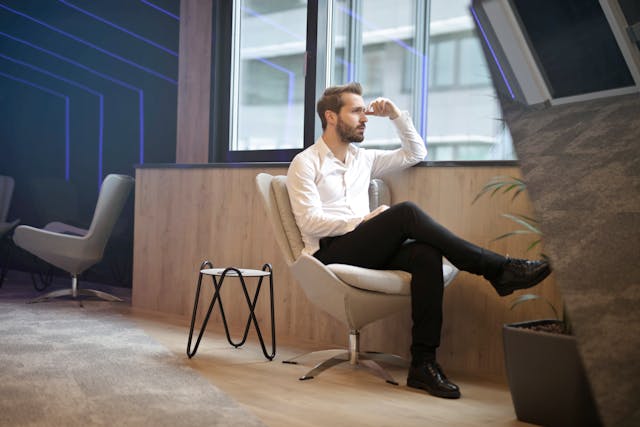 A man sitting down, visibly reviewing or thinking some opportunities and challenges ahead.