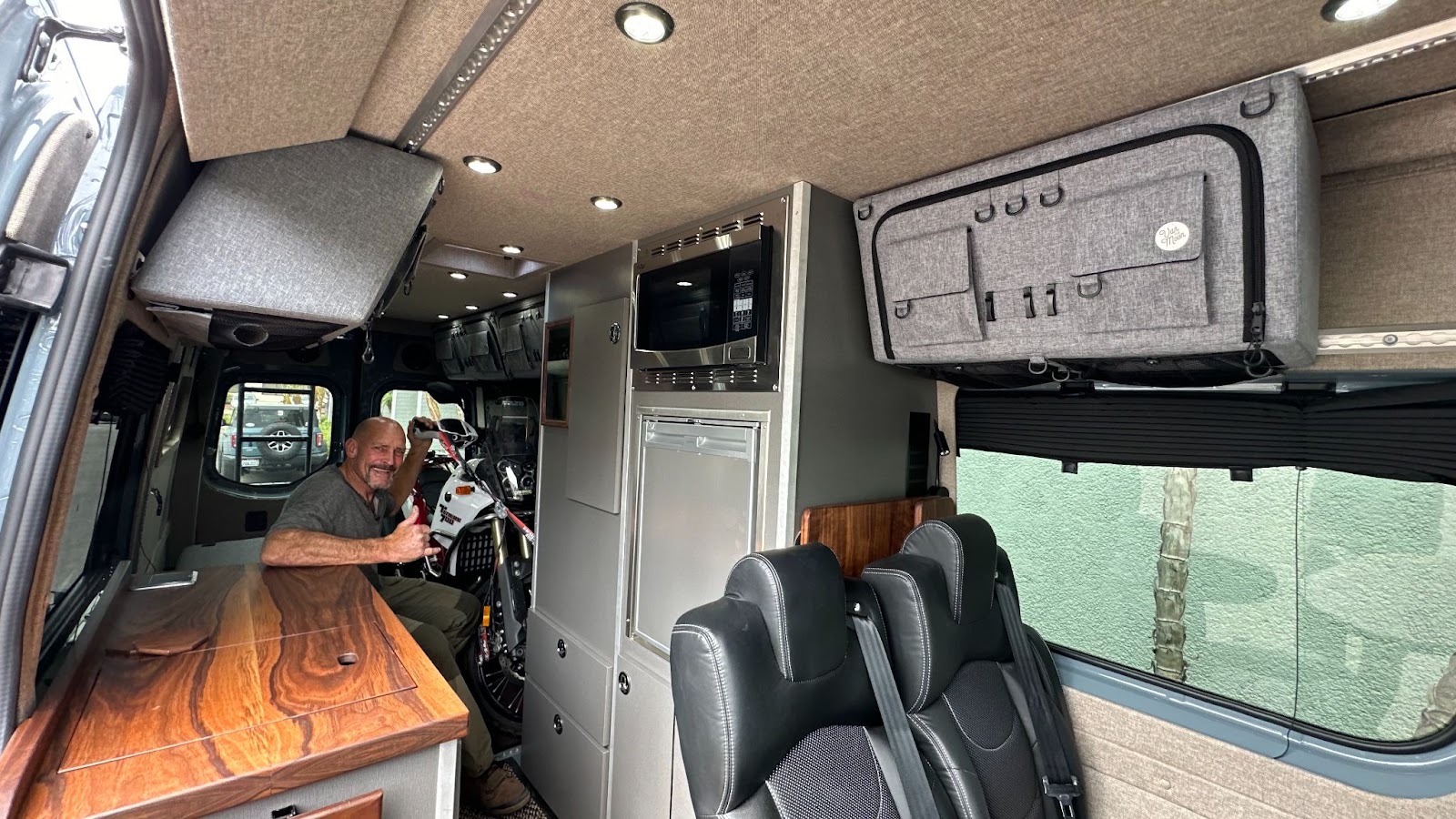 the inside of a campervan with a guy and his dirt bike in there 