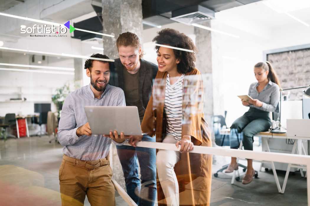 Group of colleagues looking at a laptop screen in modern office