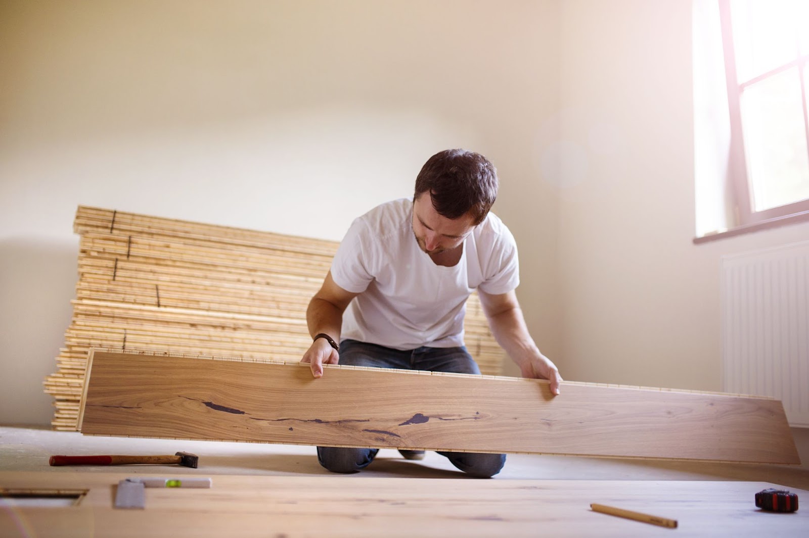A handyman is installing a wooden floor.