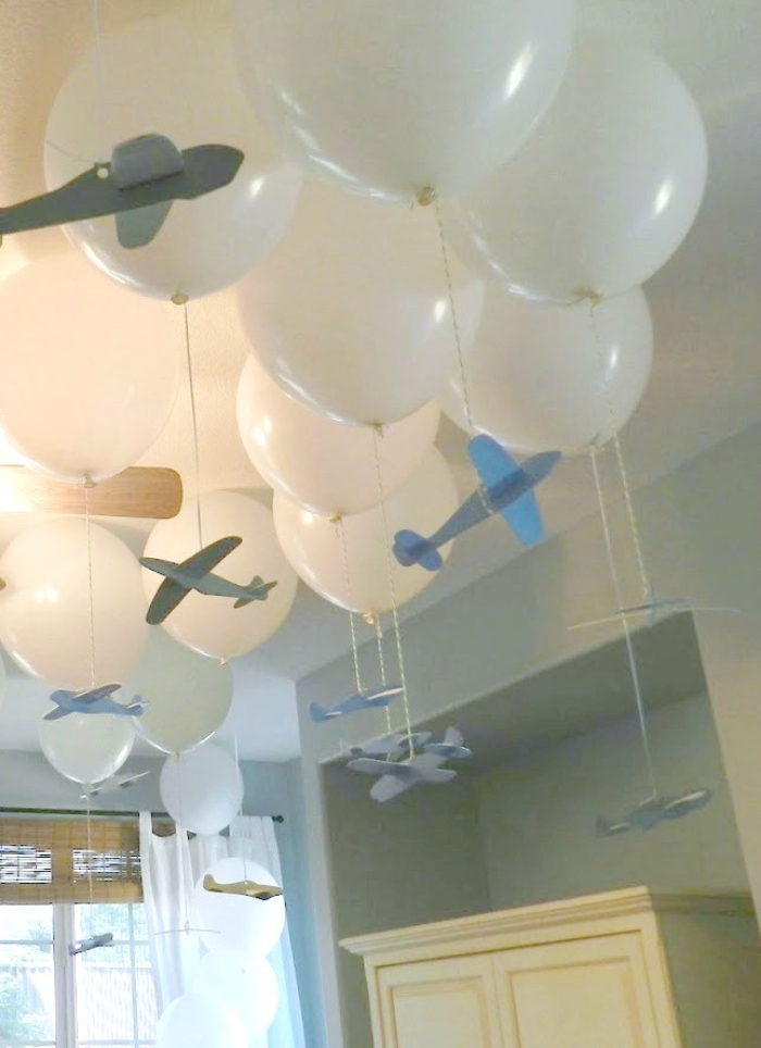 white balloons with blue paper planes