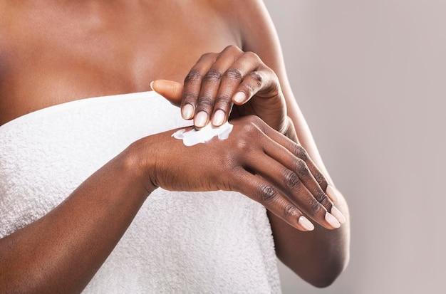 African girl applying body milk on her hand