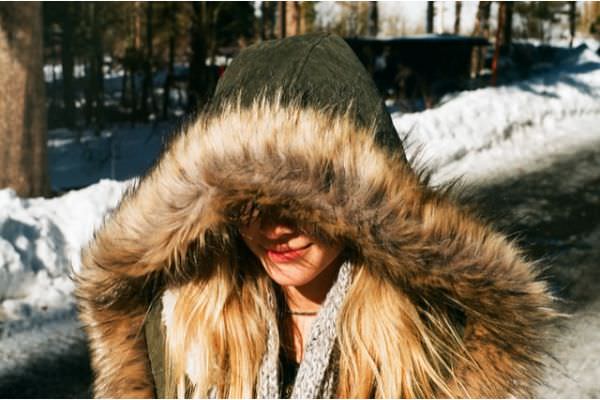 junge_frau_trägt-einen_wintermantel_mit_kunstfell_abschluss