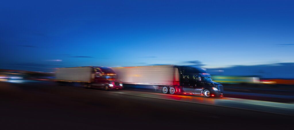 Two semi-truck sdriving on the highway at night - motion blur -  fatality analysis reporting system by the FCMSA