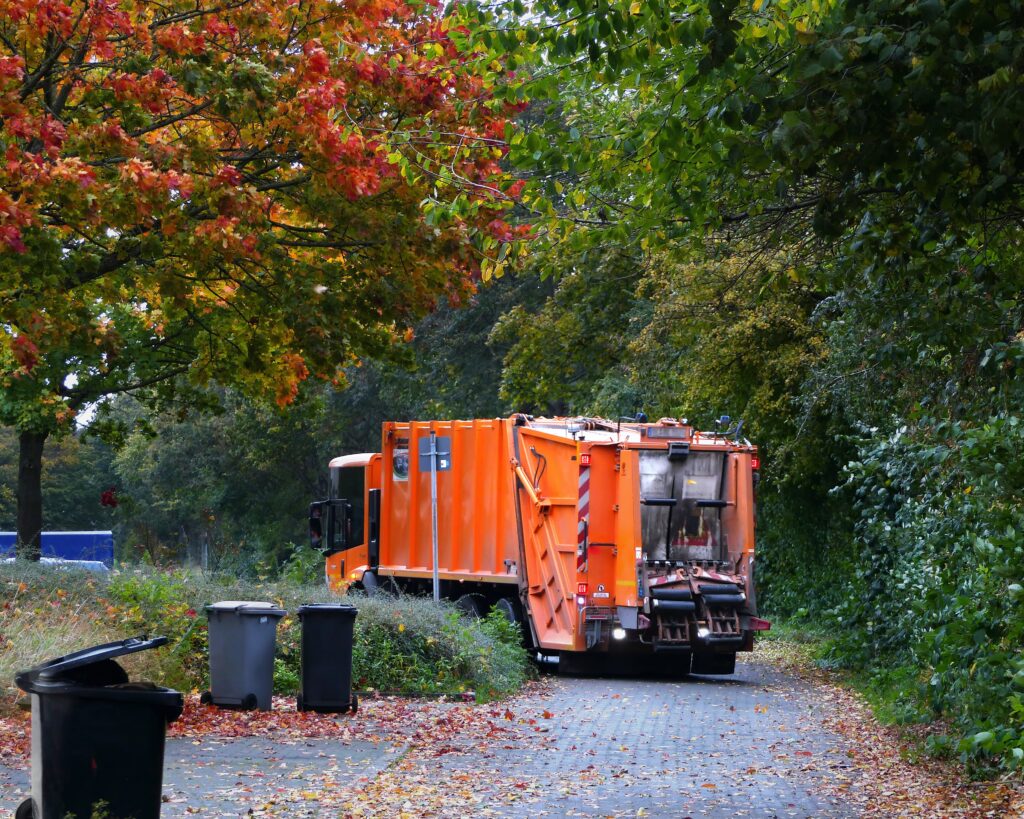 garbage truck driving down a small indianapolis neighborhood road