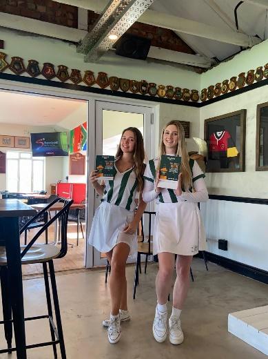 Two women in cheer uniforms holding up books

Description automatically generated with medium confidence