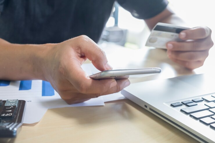 Person making an online payment using a smartphone and credit card.