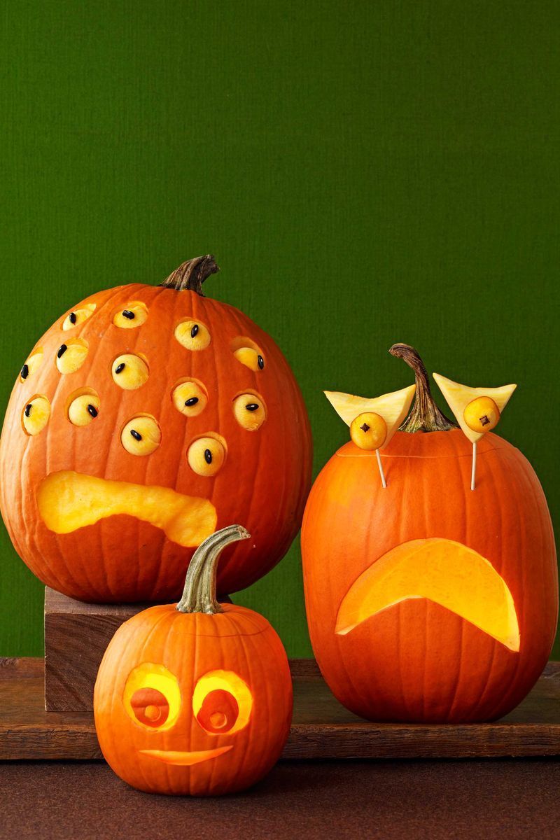 pumpkin carving ideas, three pumpkins carved with different eye designs