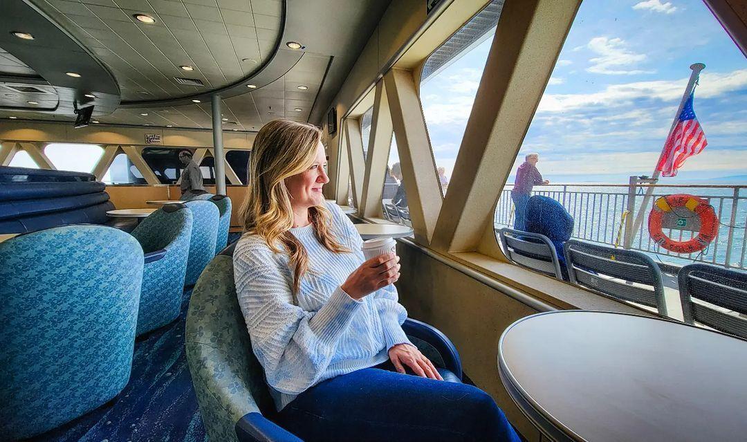 Image of a woman drinking a coffee inside the ferry