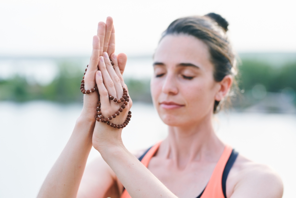 Serene women touching beads during meditation